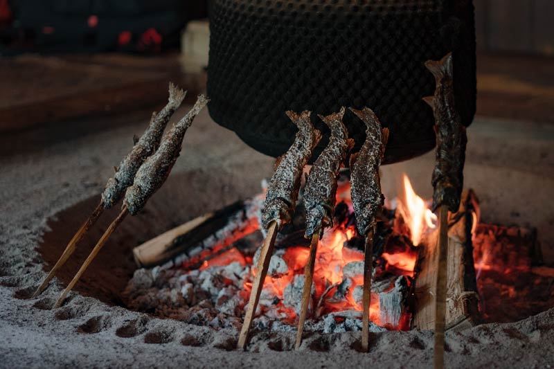 昔ながらの囲炉裏の薪火でじっくりと焼く、岩魚の塩焼きのイメージ画像